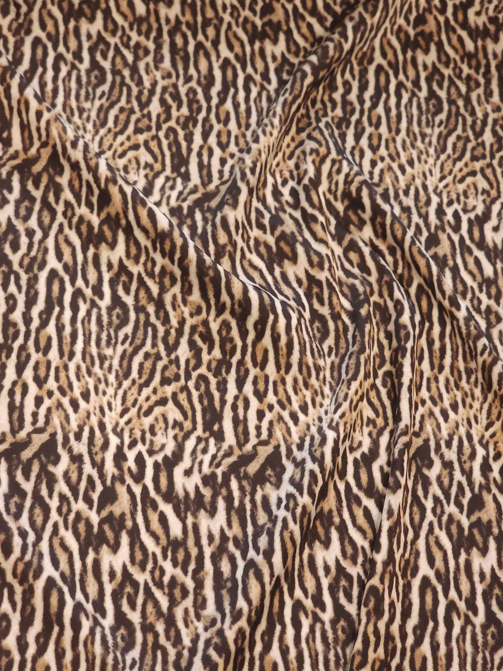 Leopar desenli ipeksi saten kumaş, parlak yüzeyi ve dökümlü yapısıyla bluz ve elbiselik
